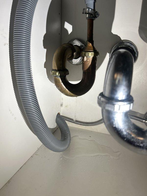 Responded to a water leak locate service call and performed a thorough inspection of the under-sink plumbing system. Upon examination, identified multiple areas of concern including an aging brass P-trap assembly with corroded connections, oxidized copper piping showing significant patina buildup, and deteriorating flexible drainage hoses. Documented the condition of all plumbing fixtures, noting the mixed-age components with both older brass and newer chrome assemblies present. Inspected all trap connections, tailpiece fittings, and wall-mounted drain pipes for signs of active leaking or moisture intrusion. Photographed the existing plumbing configuration to provide visual documentation of component conditions and potential failure points requiring future attention.