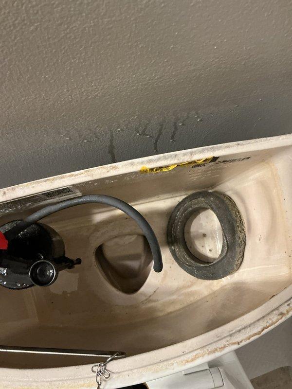 Responded to overflow issue at toilet tank where water was escaping through the flush handle mechanism. Upon inspection, determined that the water level in the tank was set too high, causing overflow through the handle assembly. Adjusted the fill valve to lower the maximum water level in the tank, preventing overflow while maintaining proper flush function. Technician will return with replacement part for complete repair.
