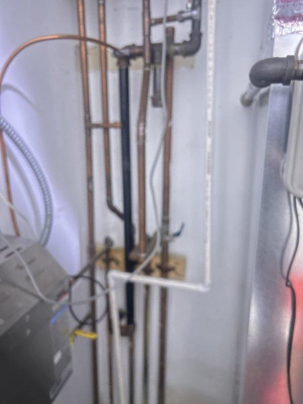 Completed plumbing system inspection and assessment in utility closet area containing water heater, expansion tank, and multiple supply and drainage lines including copper, PVC, and black iron piping. Documented existing plumbing infrastructure configuration and mechanical room setup for repair consultation and future service planning.