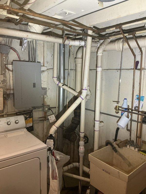 Responded to first-call service appointment at 9AM to assess plumbing system in basement utility area. Upon arrival, conducted comprehensive inspection of existing plumbing infrastructure including water heater installation, supply lines, and drainage systems. Documented current conditions of copper piping, PVC drainage lines, and mechanical connections throughout the utility space. Evaluated water heater unit and associated piping for proper installation and code compliance. Inspected vertical and horizontal pipe runs secured to concrete block walls, verifying bracket and strap mounting integrity. Photographed all plumbing components, electrical panel proximity to water sources, and overall system configuration for service records. Completed assessment of utility room mechanical systems and provided recommendations for necessary repairs or upgrades identified during inspection.