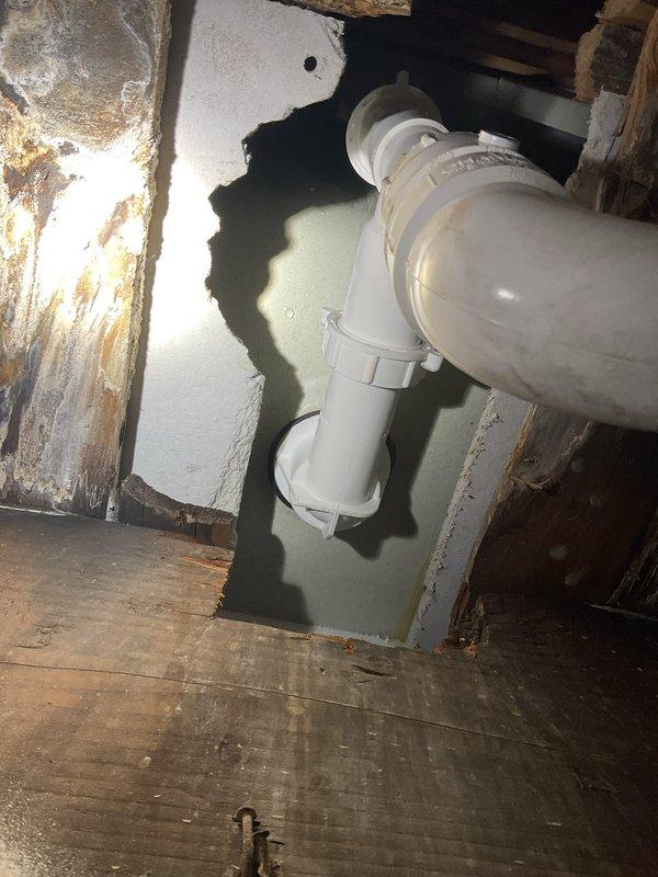 Responded to warranty callback for recurring bathtub leak previously repaired. Upon inspection, discovered failed P-trap assembly with active water infiltration causing extensive damage to surrounding drywall and structural components. Removed deteriorated trap, replaced with new PVC P-trap assembly and connections, repaired water-damaged wall section, and verified proper drainage with no leaks detected upon completion.