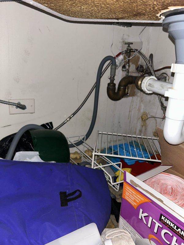 Responded to service call for dishwasher with standing water issue. Upon inspection, identified kinked dishwasher drain hose beneath kitchen sink causing improper drainage. Accessed under-sink plumbing assembly, straightened and properly reinstalled the dishwasher drain hose to ensure proper water flow and drainage. Verified dishwasher drains correctly with no standing water remaining. Documented conditions with photos for records.