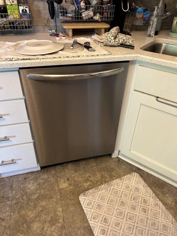 Responded to service call for dishwasher with standing water issue. Upon inspection, identified kinked dishwasher drain hose beneath kitchen sink causing improper drainage. Accessed under-sink plumbing assembly, straightened and properly reinstalled the dishwasher drain hose to ensure proper water flow and drainage. Verified dishwasher drains correctly with no standing water remaining. Documented conditions with photos for records.