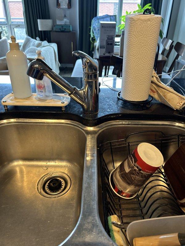 Completed installation of chrome pull-out faucet on double-basin stainless steel kitchen sink during scheduled building shutdown window. All materials were provided by client as specified. Verified proper water supply connections with braided flex lines to shut-off valves, tested drain assemblies and P-traps for leaks, and confirmed full functionality of pull-out spray mechanism upon completion.