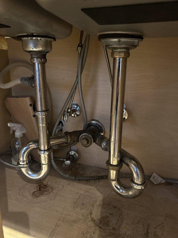 Completed installation of chrome pull-out faucet on double-basin stainless steel kitchen sink during scheduled building shutdown window. All materials were provided by client as specified. Verified proper water supply connections with braided flex lines to shut-off valves, tested drain assemblies and P-traps for leaks, and confirmed full functionality of pull-out spray mechanism upon completion.