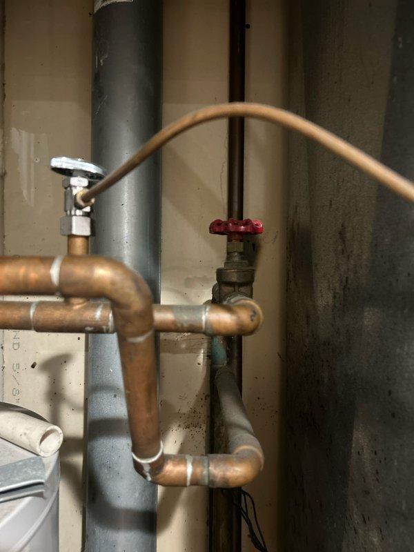 Performed routine maintenance flush on residential tanked water heater. Drained sediment buildup from tank through drain valve, flushed system with fresh water until discharge ran clear, and verified proper operation of temperature and pressure relief valve. Inspected copper supply lines, shut-off valves, and connections for leaks or corrosion—all components found in serviceable condition with no immediate concerns noted.