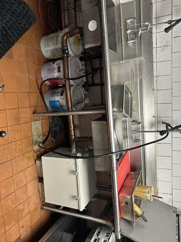 Installed commercial-grade water filtration system beneath prep sink in commercial kitchen, including mounting multiple filter canisters on copper supply lines and securing all connections. Verified proper water flow through filtration system and tested for leaks at all connection points to ensure system integrity for food service operations.
