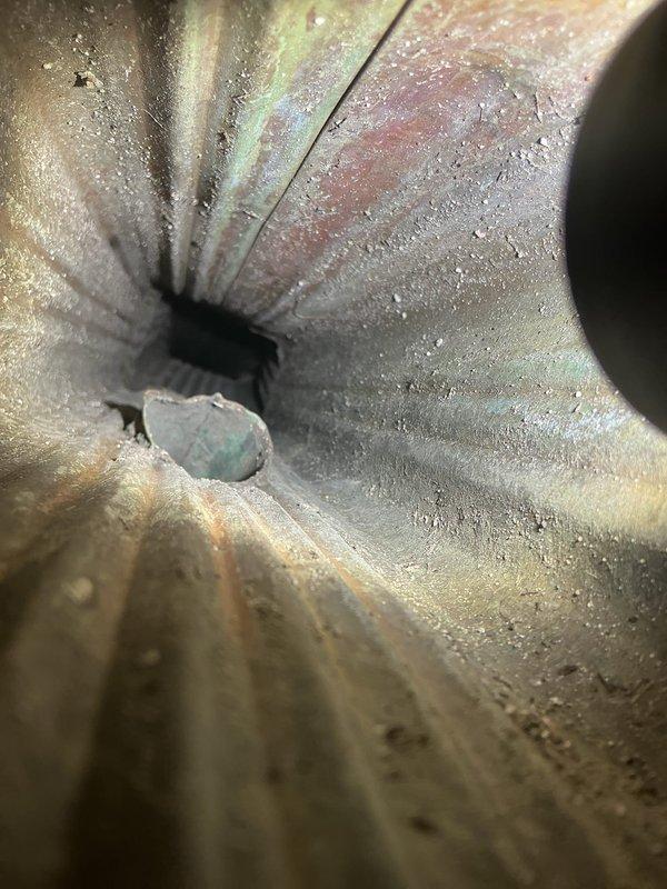 Responded to basement water intrusion complaint occurring during rain events. Conducted comprehensive leak location assessment of exterior porch area and interior drainage system. Inspection revealed exterior brick wall showing significant weathering, algae growth, and compromised coping stones allowing water penetration. Interior investigation identified improperly installed or disconnected floor drain with no functional connection to drainage system, resulting in water discharge directly onto basement floor. Documented conditions with photographic evidence showing exterior water entry points at porch perimeter and interior ductwork/drainage components. Identified dual water intrusion sources: exterior envelope failure at porch interface and deficient interior drain installation. Provided diagnostic findings to clarify conflicting assessments from previous contractors.