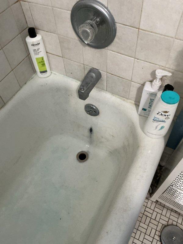 Responded to service call for brown water discharge from bathtub faucet and slow-draining bathroom sink. Upon arrival, inspected bathroom plumbing fixtures and identified discoloration issues in bathtub with visible staining on porcelain surface. Assessed drainage system for blockages affecting sink performance. Examined supply lines and fixture connections to determine source of water discoloration. Documented existing conditions including tile surrounds, chrome fixtures, and floor drain assembly. Performed diagnostic evaluation of plumbing system to address both water quality and drainage concerns in affected bathroom.