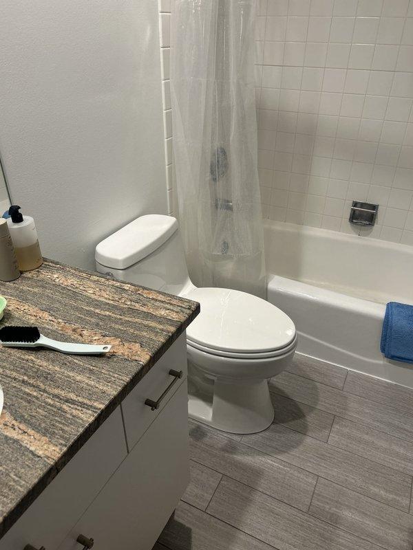 Responded to report of water leak from ceiling near bathroom area. Conducted thorough visual inspection of bathroom fixtures, plumbing connections, and surrounding areas to locate source of moisture intrusion. Examined toilet, vanity plumbing, bathtub/shower assembly, and all visible supply and drain lines. Inspected tub spout, faucet assembly, overflow plate, and drain connections for signs of active leaking or water damage. Documented conditions with photographs for service records. Bathroom currently out of service pending leak resolution.