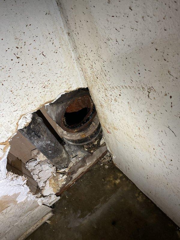 # Plumbing Service - Clogged Drain/Sink

Responded to clogged bathtub drain with slow drainage and visible debris accumulation. Upon inspection, found significant buildup of hair, soap residue, and foreign material obstructing the drain stopper mechanism and trap assembly. Removed chrome drain stopper assembly and extracted accumulated debris from the drain opening. Cleared blockage using appropriate drain cleaning tools and restored proper water flow. Tested drainage to confirm complete resolution of the clog. Additionally, inspected deteriorated cast iron drain pipe penetration in basement utility area showing advanced corrosion, rust staining, and compromised wall integrity with moisture damage to surrounding building materials, recommending future repair or replacement to prevent potential leaks and further structural deterioration.