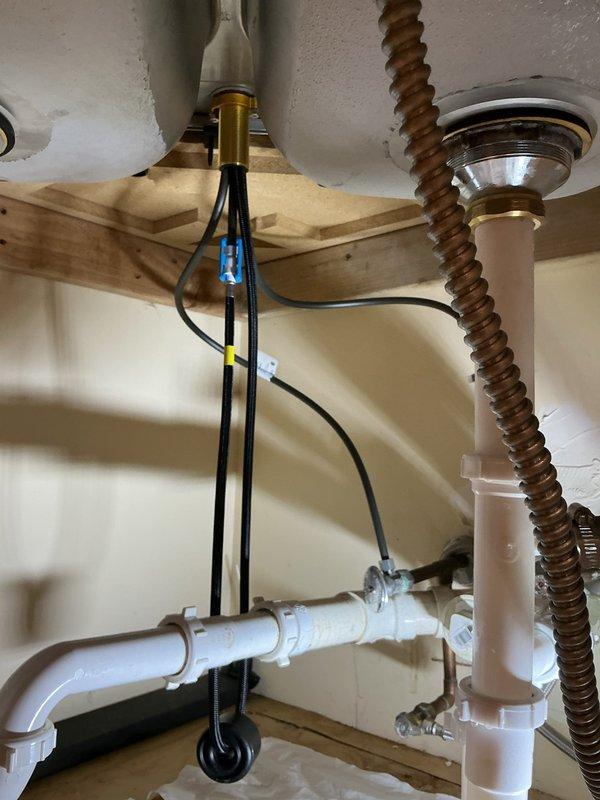 Completed installation of new faucet fixture including full under-sink plumbing configuration. Installed water supply connections with chrome shut-off valves, braided flexible supply lines with proper hose clamps, and complete PVC drain assembly with P-trap configuration to ensure proper drainage and prevent sewer gas backup. All connections tested and verified leak-free with proper water flow.