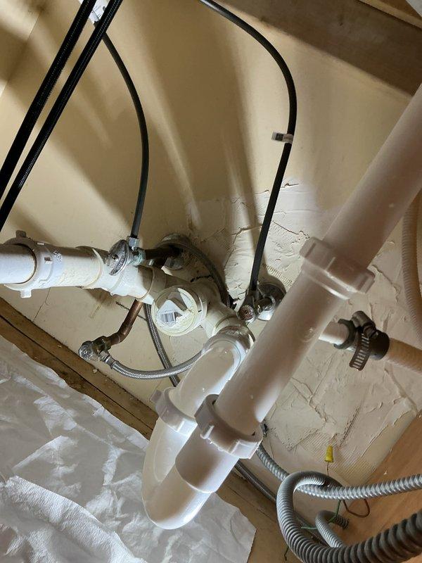 Completed installation of new faucet fixture including full under-sink plumbing configuration. Installed water supply connections with chrome shut-off valves, braided flexible supply lines with proper hose clamps, and complete PVC drain assembly with P-trap configuration to ensure proper drainage and prevent sewer gas backup. All connections tested and verified leak-free with proper water flow.