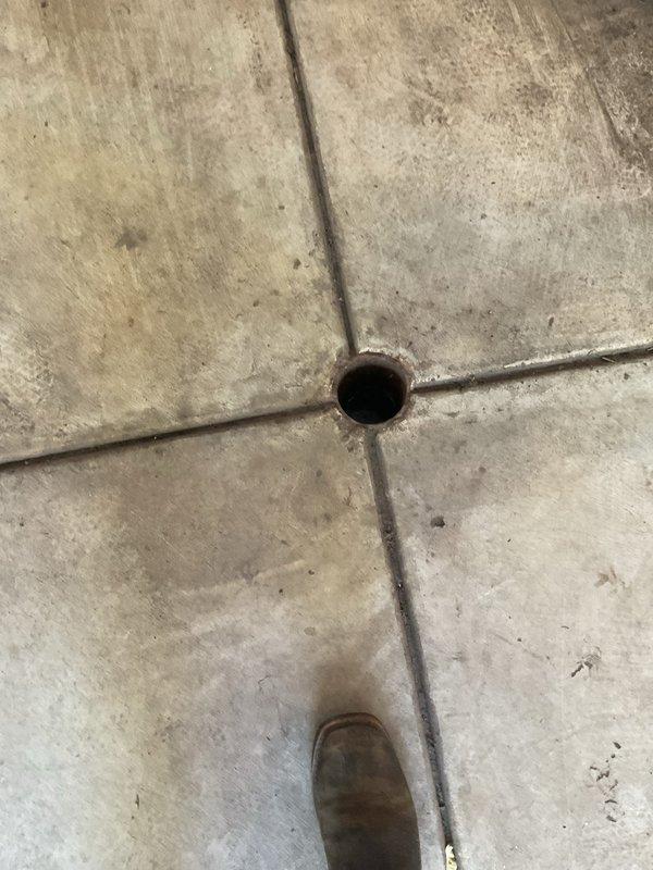Responded to slow drain complaint at residential property. Upon arrival, located floor drain in garage area and performed inspection of drainage system. Utilized professional drain cleaning equipment, including pressure washing apparatus with hose assembly, to clear obstruction and restore proper flow. Verified drainage functionality upon completion of cleaning procedure.