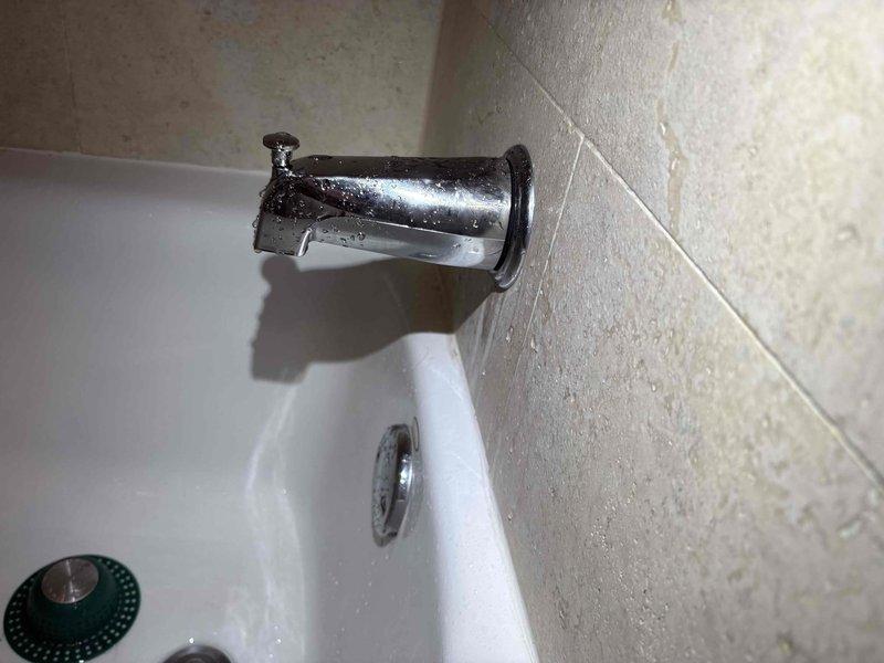 Responded to building-wide water leak reported in condominium garage. Upon inspection, traced source to corroded copper supply line penetration at wall interface showing active seepage and significant oxidation. Isolated affected water supply, removed deteriorated pipe section, and installed new copper piping with proper sealing at wall penetration point. Verified bathtub spout connection and associated plumbing fixtures for proper operation and absence of additional leaks. Tested system under pressure, confirmed no active water flow, and restored water service to building.