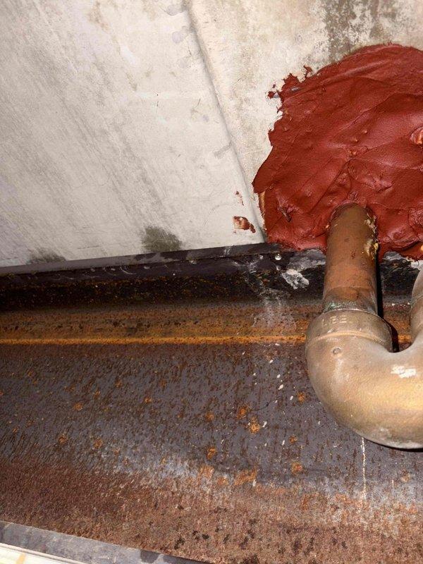 Responded to building-wide water leak reported in condominium garage. Upon inspection, traced source to corroded copper supply line penetration at wall interface showing active seepage and significant oxidation. Isolated affected water supply, removed deteriorated pipe section, and installed new copper piping with proper sealing at wall penetration point. Verified bathtub spout connection and associated plumbing fixtures for proper operation and absence of additional leaks. Tested system under pressure, confirmed no active water flow, and restored water service to building.
