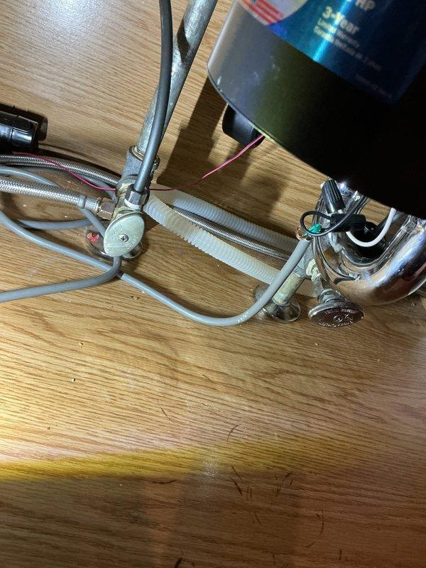 Successfully removed existing kitchen faucet and installed new customer-provided brushed stainless steel faucet with single-handle operation. Disconnected water supply lines from previous fixture, removed old mounting hardware from undermount sink configuration, and prepared mounting surface on light-colored quartz countertop. Installed new faucet assembly with proper sealing, connected braided metal supply lines to hot and cold water valves, and verified secure mounting to prevent movement. Tested water flow and checked all connections for leaks, confirming proper operation of new fixture. All plumbing connections under cabinet are secure with no drips detected.