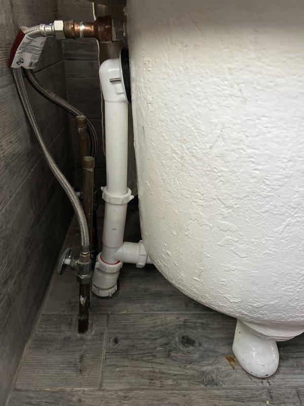 Responded to water leak originating from master bedroom en-suite shower that was causing ceiling stains in the living room below. Upon inspection, identified failed gasket seal on the shower drain assembly as the source of water intrusion. Removed existing drain components and replaced the deteriorated gasket with new sealing materials to prevent further water migration through the floor assembly. Tested the shower drain system under running water conditions to verify proper seal and confirm no active leakage. Inspected associated plumbing connections including supply lines, shut-off valves, and waste piping to ensure overall system integrity. Documented existing plumbing conditions including copper supply lines showing age-related oxidation and PVC drain assemblies. All connections were verified tight and functioning properly upon completion.