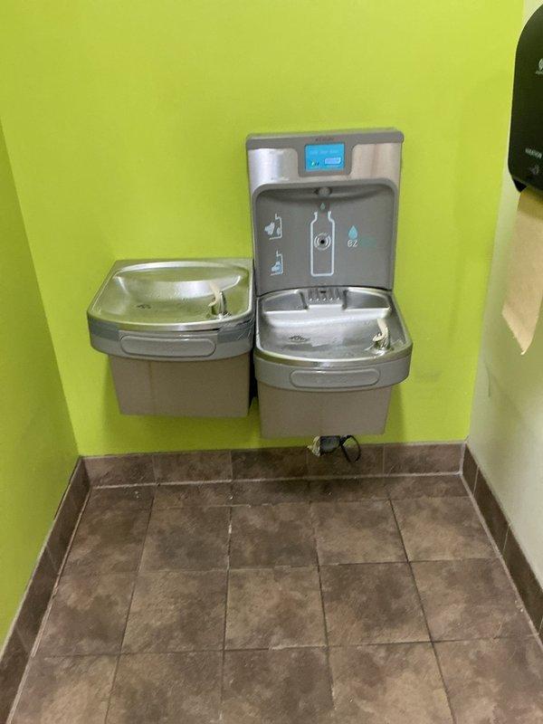 Responded to service call for water fountain system experiencing drainage issues. Upon inspection, accessed internal mechanical compartment and identified buildup affecting drainage components and filter assembly. Documented current condition of unit's internal mechanisms, including filter canister, connection tubing, and associated plumbing components. Discussed replacement options for aging water fountain system due to extent of wear and accumulated mineral deposits affecting performance.