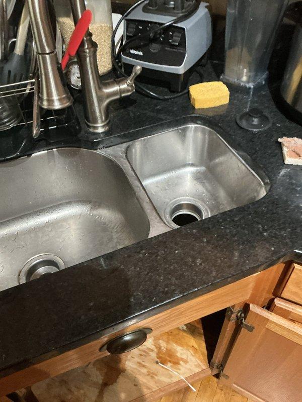 Responded to service call for garbage disposal that had become detached from sink mounting assembly. Upon arrival, inspected under-sink cabinet area and confirmed disposal unit had separated from sink flange connection. Verified disposal unit was intact and undamaged. Cleaned and prepared mounting surfaces, reinstalled garbage disposal to sink flange using proper mounting hardware and gaskets, and torqued mounting ring to manufacturer specifications. Tested unit for proper operation, checked all connections for leaks, and verified secure attachment to sink basin. Unit now functioning properly with no leaks detected.