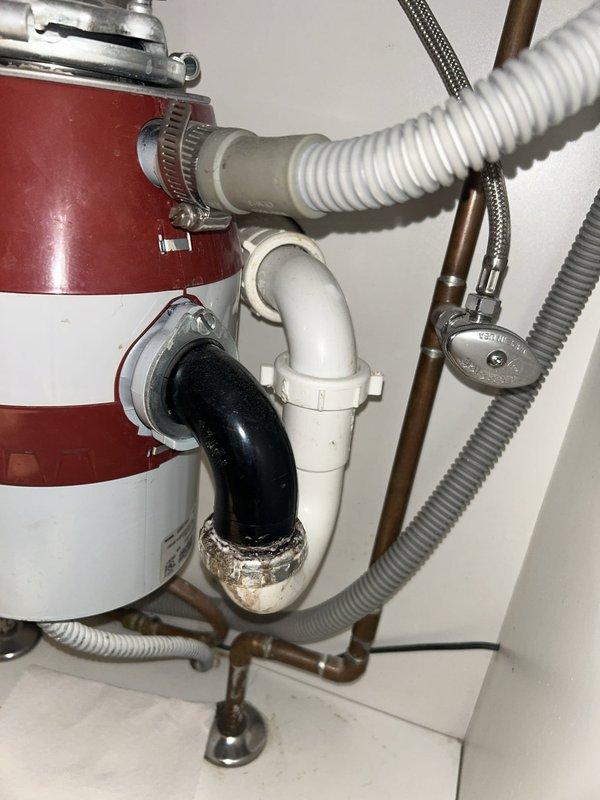 Responded to service call for leaking kitchen sink with suspected garbage disposal leak. Upon inspection, identified active leak originating from the garbage disposal's discharge connection and mounting assembly. Removed and inspected the existing garbage disposal unit, which displayed corrosion at the discharge elbow connection and compromised sealing at the sink flange mounting ring.

Disassembled the discharge plumbing assembly, including the P-trap and connecting drain lines. Replaced worn rubber gaskets and reinstalled discharge elbow with new stainless steel hardware and plumber's putty at all connection points. Resealed the sink flange mounting assembly with fresh plumber's putty and tightened the mounting ring to manufacturer specifications. Reconnected the P-trap assembly with new slip joint washers to ensure watertight connections throughout the drainage system.

Tested the garbage disposal operation and ran water through the system for several minutes to verify all connectio