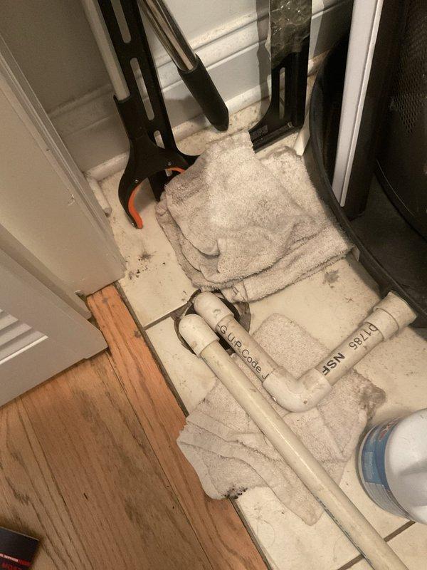 Responded to a reported water leak affecting the downstairs unit and inspected the HVAC condensate drain at the utility closet. Located the leak source at the clogged/non-draining condensate line, disconnected the PVC drain piping to access the floor drain, and cleared the obstruction to restore proper drainage. Absorbed standing water with towels and verified the area was clear of active leaking.