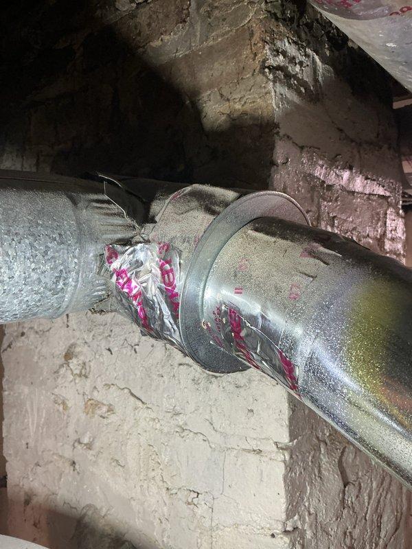 Inspected the water heater venting system following a home inspection report of carbon monoxide leakage and found the galvanized flue connector joint improperly sealed with torn, peeling foil tape over deteriorated insulation, allowing flue gas escape. Removed the compromised tape and insulation, then re-secured and properly sealed the vent connector joint and wall penetration to restore a gas-tight flue path. Verified the repair with a combustion and leak check to confirm no flue gas spillage.