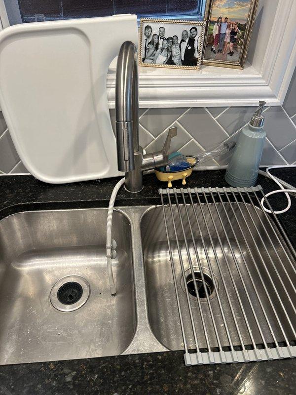 Installed a garbage disposal unit beneath the double-basin kitchen sink, securing it to the sink flange with the mounting ring and connecting the discharge outlet to the existing P-trap and drain line. Verified tight, leak-free connections at the trap, drain hose, and supply-line fittings, with no signs of corrosion or seepage. Work area was protected and left clean upon completion.