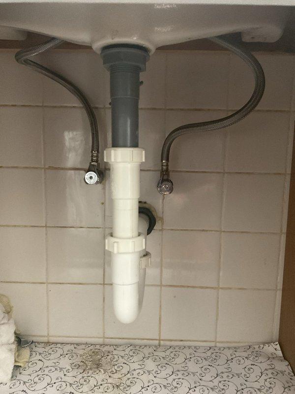 Responded to a leaking connection beneath the bathroom vanity and inspected the PVC P-trap assembly, tailpiece, slip-nut couplings, and flexible supply lines to the angle-stop valves. Isolated the source of the leak, then resealed and tightened the affected slip-joint connection, confirming a dry, watertight fitting under flow. Verified the main water meter and shutoff valve in the basement were accessible and in good working order.