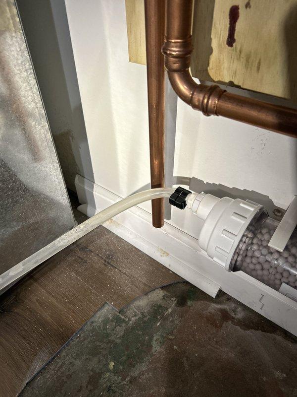 Responded to a warranty callback for a persistent slow drip at the tankless water heater condensate neutralizer. Inspected the neutralizer filter housing, condensate drain tubing, and PVC/clamp connections, and addressed the leak at the condensate line to stop discharge onto the basement floor. Verified the condensate drain assembly was secure and draining properly.