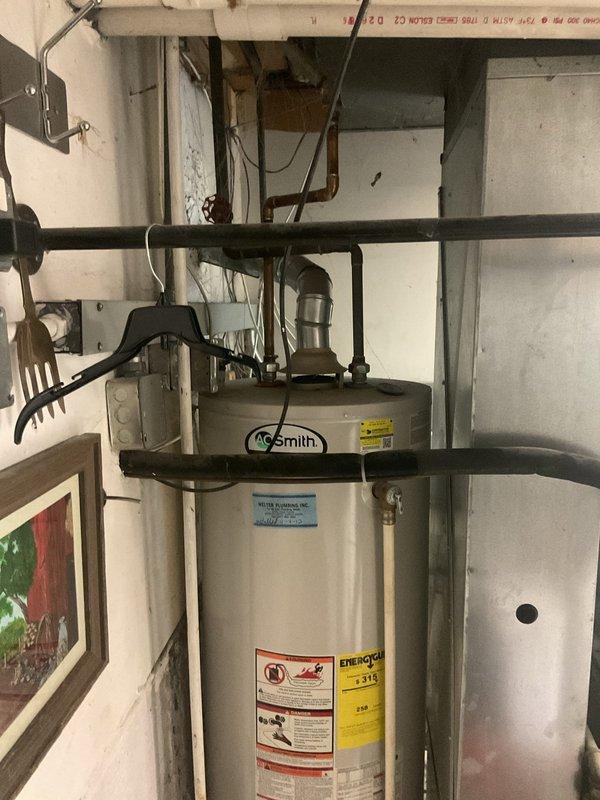 Replaced the existing gas-fired water heater with a new A.O. Smith atmospheric-vent unit. Disconnected and drained the old tank, set the new unit on its base, and reconnected the water supply lines, gas control assembly, and flue vent. Verified the gas connections, pilot ignition, and flue draft, and confirmed the unit was operating properly with no leaks.