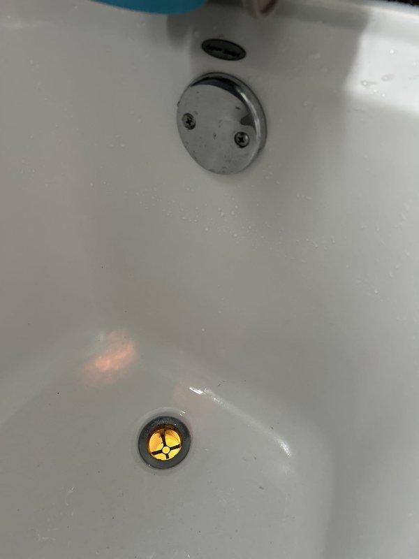 Performed a water leak locate, inspecting the bathtub overflow and drain assembly and tracing the associated drain piping beneath the floor, where the PVC drain line, trap, and fittings between the joists were examined. Water staining was observed on the adjacent framing, indicating a probable leak at the tub drain/overflow connections. Repairs were not started during this visit and will be completed on a follow-up visit.