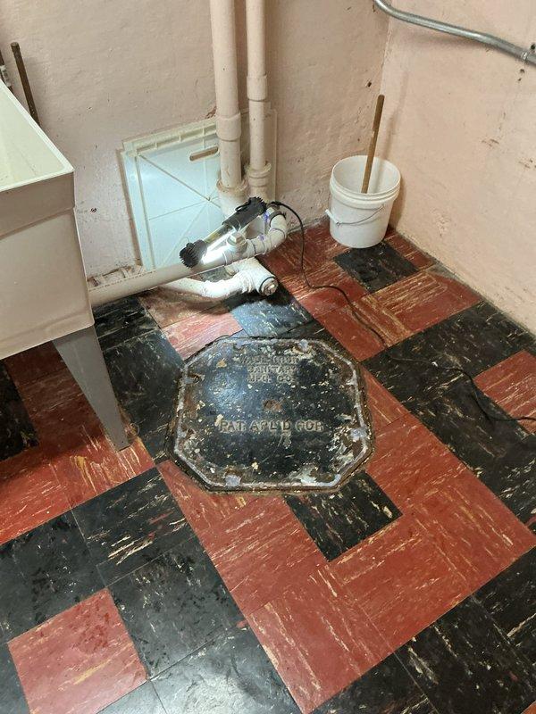 Responded to a clogged kitchen sink drain complaint and inspected the drain line and accessible cleanout/drain assembly in the basement utility area. Cleared the blockage from the drain line, restoring proper flow, and verified normal drainage from the fixture.