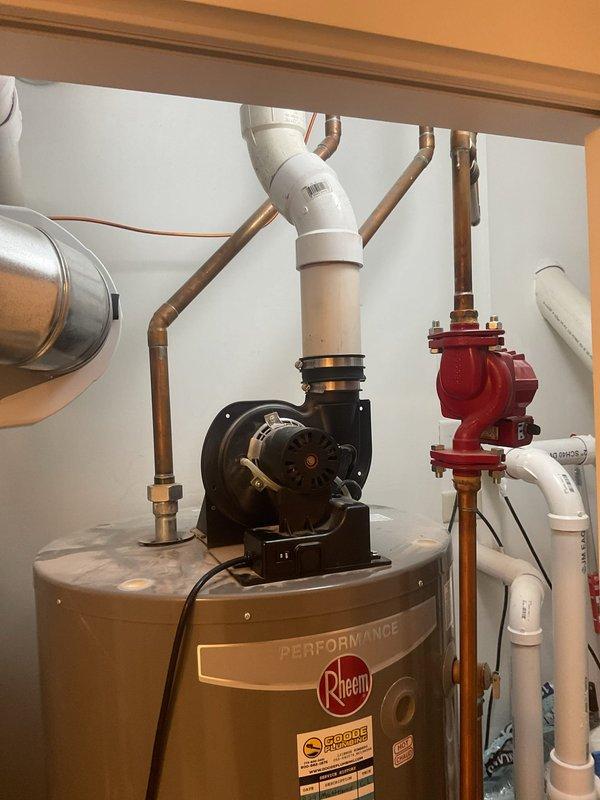 Inspected a 75-gallon, 7-year-old Rheem power-vent tank water heater reported to be intermittently locking out at least once daily, and documented the unit's condition, including the power-vent blower assembly, PVC exhaust venting, supply piping, and circulator pump. No visible signs of rust, frost, or tank damage were observed, so the lockout is likely tied to the power-vent or ignition control system, and further diagnostic testing is recommended to isolate the root cause.
