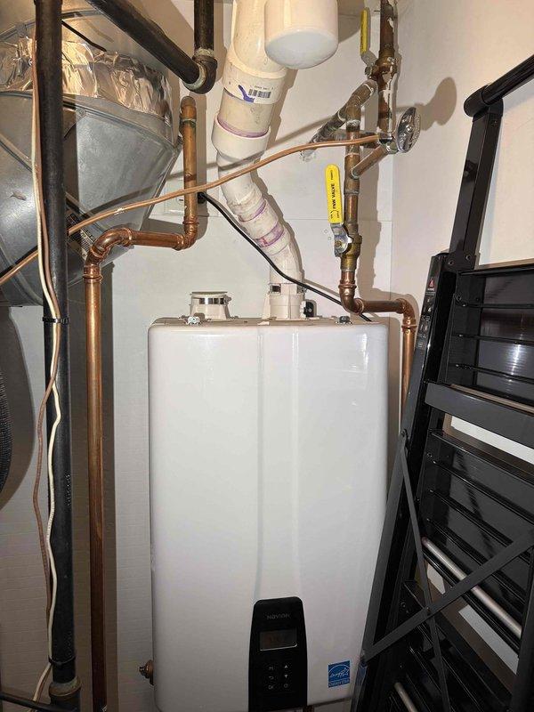 Performed routine maintenance flush on a wall-mounted Navien tankless water heater with no deficiencies found; the unit, supply piping, and venting showed no visible leaks, corrosion, or damage. Inspected the toilet tank and observed an aged fill valve assembly with mineral and sediment buildup, discolored water, and a partially lifted fill valve cap, indicating the need for further service. Customer is interested in establishing an annual maintenance schedule, with additional evaluation requested for the garbage disposal, cold-side water filter replacement, and ice maker.