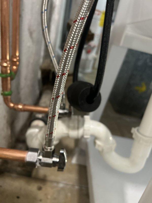 Inspected the existing washer, dryer, and utility sink connections and found the aging copper supply lines, angle-stop valves, and PVC drain assembly in need of replacement to accommodate the new washer and dryer installation. Assessed the exposed copper piping and overhead cast iron lines, confirming no active leaks, and prepared an estimate for new supply connections and drain tie-ins.