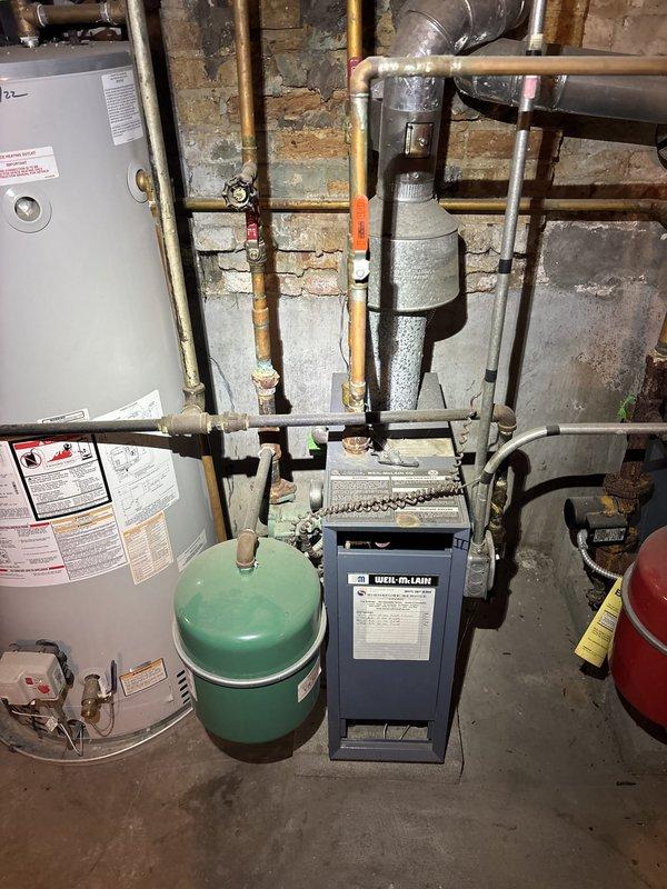Replaced the corroded copper-to-steel connection on the boiler supply piping, where galvanic corrosion and mineral buildup indicated a prior leak. Removed the deteriorated steel nipple and collar, installed new dielectric-compatible fittings, and sealed all threaded joints. Pressure-tested the system and confirmed it was leak-free, with the boiler, expansion tank, and surrounding piping operating normally.