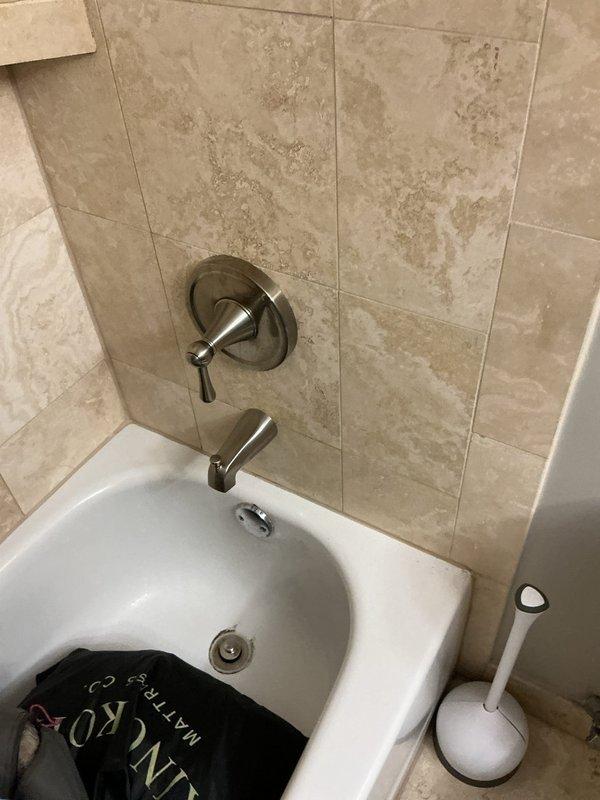 Diagnosed a leak occurring during toilet flush cycles and performed repairs to restore proper sealing and function. Inspected the toilet assembly and associated supply and drain connections, corrected the source of the leak, and tested through multiple flush cycles to confirm no further leakage. Photos taken of the adjacent tub and shower area, including an exposed shower valve access opening in the tile wall, to document existing conditions at the time of service.