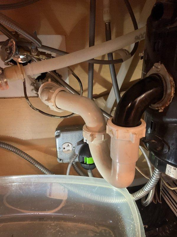 Responded to an emergency under-sink water leak and inspected the P-trap, slip-nut connections, and garbage disposal drain assembly, finding corrosion at the disposal mounting flange and a compromised seal. Replaced the worn washers and gaskets, re-seated and tightened the trap and disposal drain connections, and verified a dry, leak-free system under full water flow.
