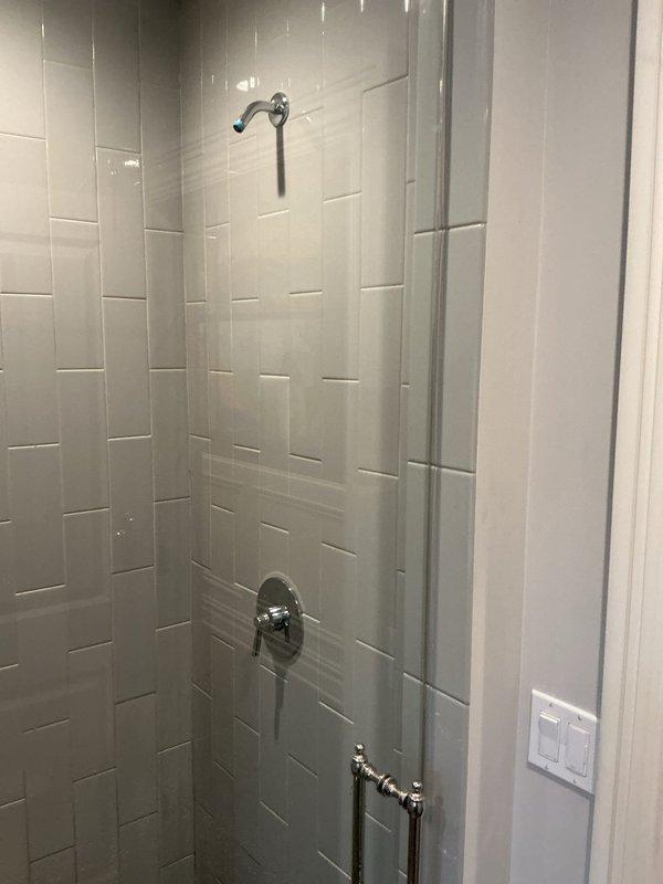 Performed annual plumbing maintenance inspection of the plumbing system, with no leaks or operational issues reported prior to service. Inspected the bathroom shower assembly, including the chrome single-handle valve and trim, and noted the shower arm is currently without a showerhead installed. Observed moisture-related wear and staining on the door casing and baseboard trim at the base of the shower enclosure, recommending monitoring for ongoing moisture intrusion.