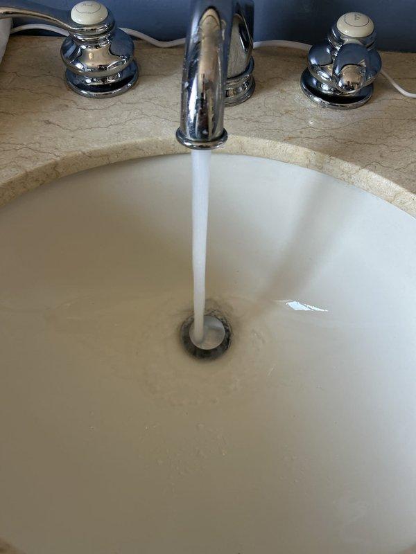 Cleared a near-complete obstruction in the upstairs bathroom sink drain, restoring full flow through the basin and drain assembly. Verified repair by running water through the fixture, confirming a steady, unobstructed stream with no standing water or slow drainage. Fixture, faucet, and surrounding surfaces were left clean with no visible damage.