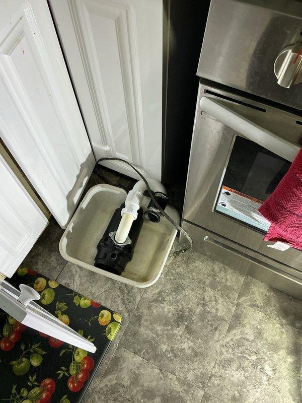 Responded to a kitchen sink drainage complaint and performed a main drain cleanout, accessing the PVC drain assembly and cast-iron stack in the lower-level piping to clear the obstruction and restore proper flow. Inspected the kitchen area, including the sump/condensate pump unit and its corrugated discharge hose and couplings, and verified the drain line was draining freely following the cleanout.