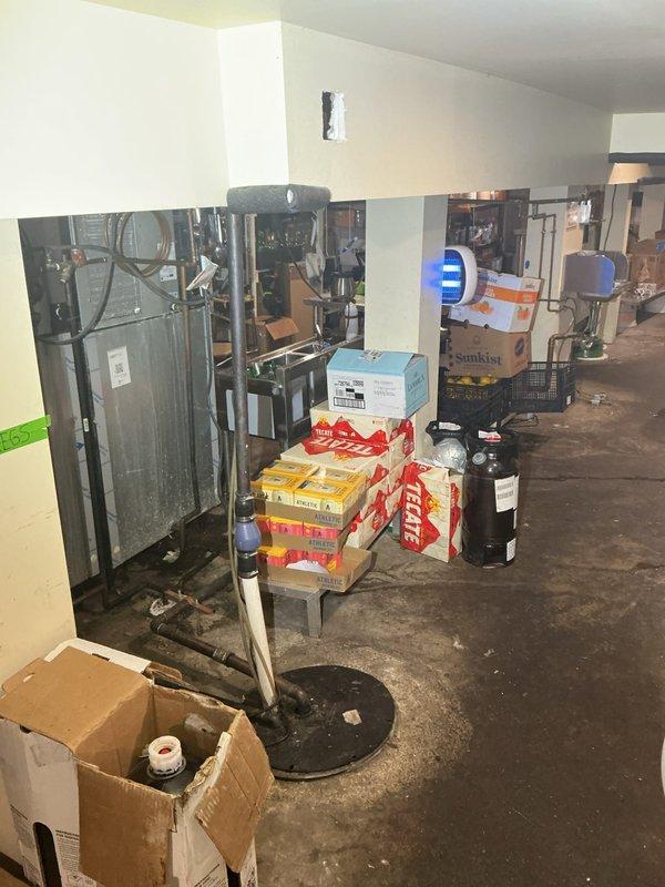 Responded to a sold repair for a water-damaged ceiling in a storage area, inspecting the affected soffit and drywall for signs of an active supply or drain leak. Documented extensive staining, paint failure, and prior patching, and verified the plumbing in the area to identify and address the source of the moisture intrusion. Also assessed the nearby sump and piping in the lower level to confirm proper condition and drainage.
