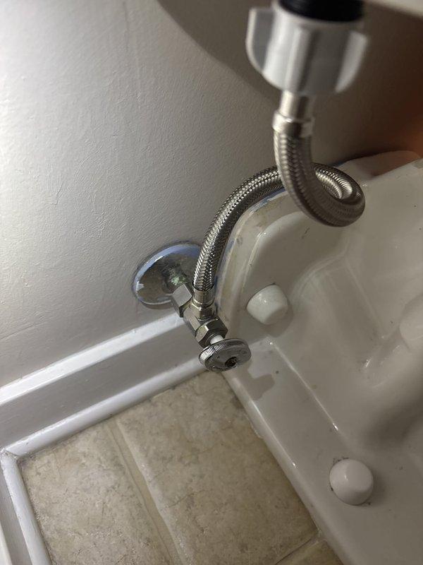 Repaired a water leak at the toilet supply connection by addressing the compression nut fitting at the angle stop valve; the supply line and valve were inspected and the connection was re-secured and leak-tested. Confirmed no leakage from the tank or supply line, and the connection is now dry and functioning properly.