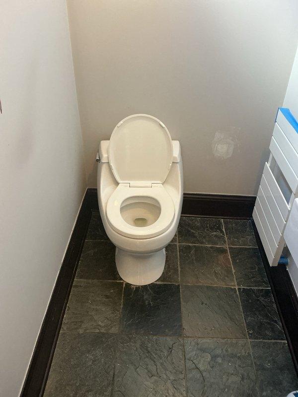 Installed a client-supplied, gravity-fed, two-bolt toilet over the existing flange on the slate tile floor, secured it with closet bolts, and connected it to the existing braided supply line and shutoff valve. Verified the connection was leak-free and operating properly, then hauled away the old toilet. Installation is covered by a 1-year warranty.