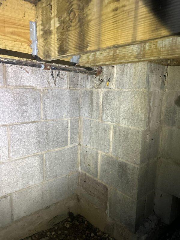 Inspected the sewer line and associated plumbing items identified during a pre-purchase home inspection, including evaluation of the sewer line for possible root intrusion and the need for rodding. Observed the lower-level crawl space and utility areas, noting moisture staining and efflorescence on masonry block walls, corrosion on metal piping, and dual sump pits with check valves that are partially obstructed by stored items and decor. Reviewed the additional reported concerns (unsecured toilet and interior/exterior faucets), with larger repairs recommended for follow-up as needed.
