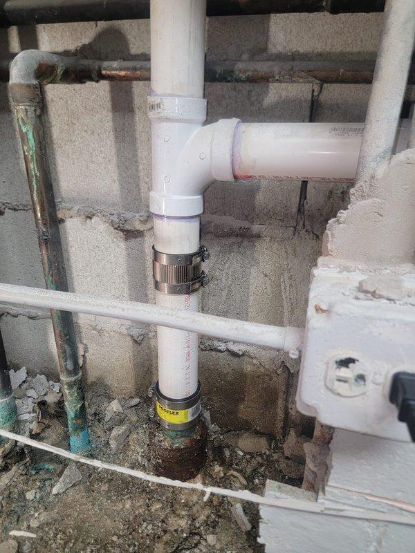 Replaced the corroded copper and cast iron drain stack sections in the basement with new PVC piping. Installed PROFLEX shielded couplings with stainless steel band clamps at the transitions to the existing drain line, restoring a secure, leak-free connection and eliminating the corrosion-related failure risk.