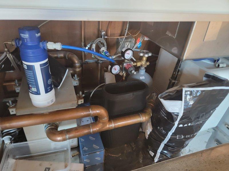 Responded to a backed-up kitchen sink drain connected to the grease trap and assessed the system for the blockage. Inspected the basement supply line and documented a leaking copper elbow with visible corrosion, mineral buildup, and degraded solder at the fittings, and recommended repair or replacement of the affected section.