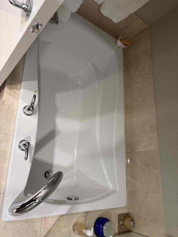 Performed an on-site plumbing estimate for the proposed remodel of the master and secondary bathrooms, including replacement of the tub and shower assemblies, two vanities, and associated faucets. Inspected and documented the existing alcove tub, which is in good condition with no visible cracks, rust, or staining, along with its deck-mounted lever handles, drain fitting, and supply fixtures. Reviewed the customer's design rendering, which specifies a tub-shower enclosure with a deck-mounted faucet, handheld shower on a slide bar, and a vanity with a widespread cross-handle faucet, and gathered the measurements and fixture details needed to prepare the quote.