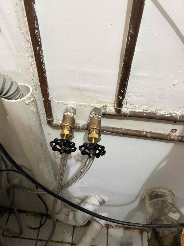 Replaced the aged supply stops with new brass quarter-turn angle valves and braided stainless steel supply lines on the copper supply stubs, restoring reliable fixture shutoff. Reconnected the drain assembly, including the PVC P-trap and corrugated drain hose, and verified all joints for leaks and proper operation. Inspected adjacent copper, PVC, and iron piping in the mechanical space and found no active leaks.